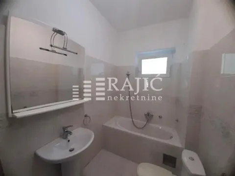 Smaller bathroom with a bathtub, washbasin, and toilet. - image 2