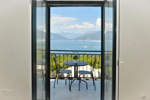 View of the sea and mountains from the terrace through open balcony doors. - image 3