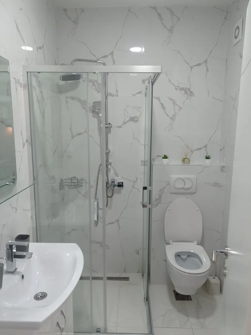 Moderne opremljeno kupatilo sa tuš kabinom, umivaonikom i toaletom.