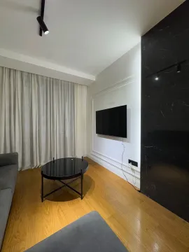 Modern living room with a sofa, black coffee table, and a wall-mounted TV. - image 4