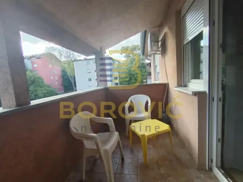 Natkriveni balkon sa plastičnim stolom i stolicama i pogledom na naselje. - image 11