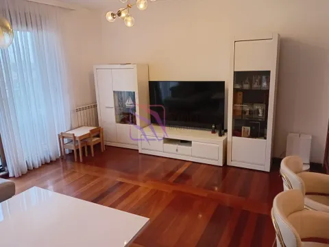 Dnevna soba sa televizorom, bijelim namještajem i drvenim podom. - image 2