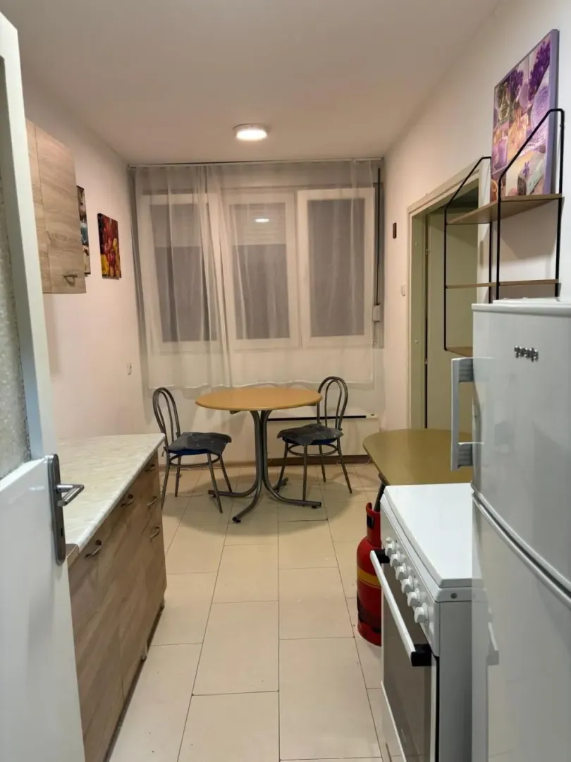 Small kitchen with a dining table and chairs by the window.