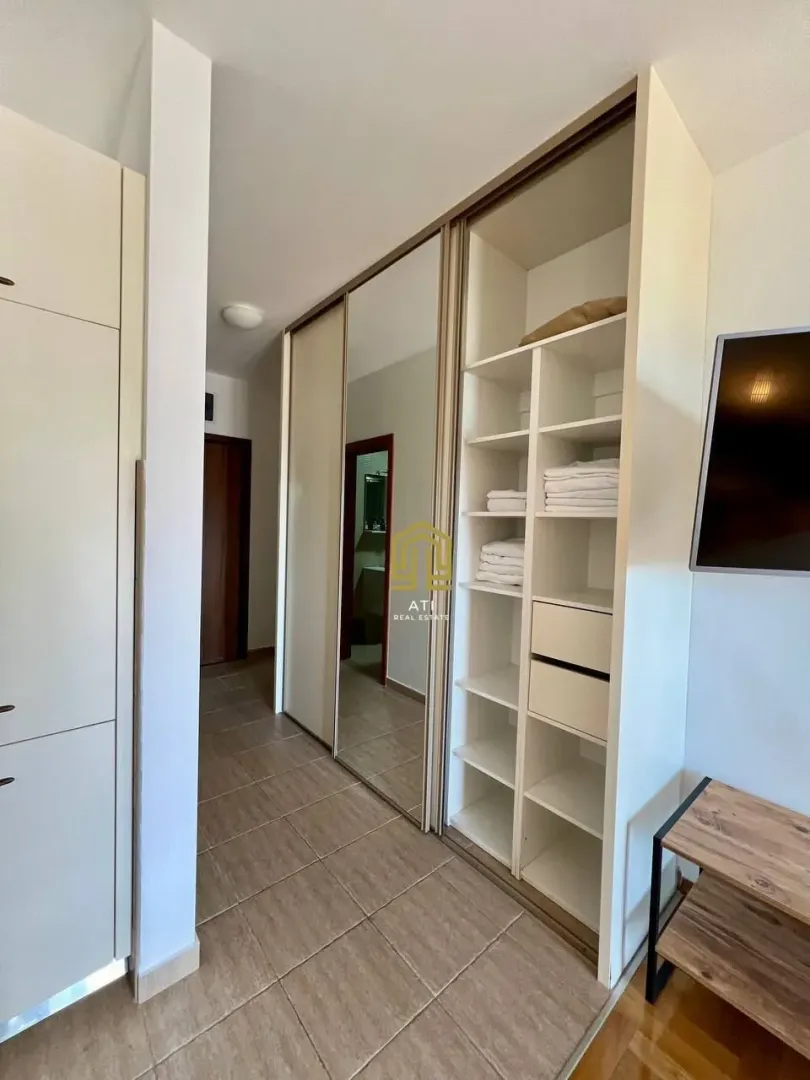 Bedroom with a large fitted wardrobe and open shelving.