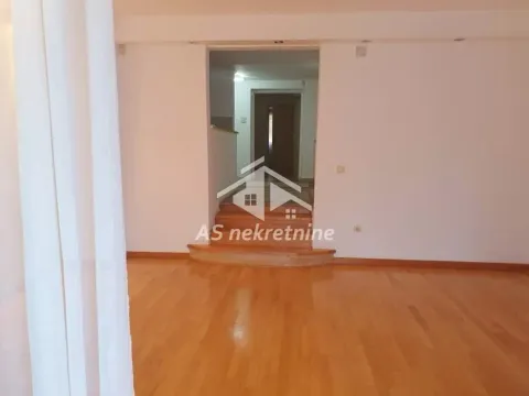 Empty living room with wooden flooring and stairs leading to another part of the apartment. - image 32
