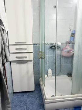 Manje kupatilo sa tuš kabinom i bijelim ormarićem. - image 8