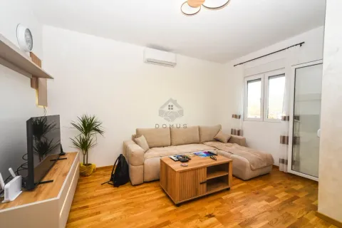 Living room with a sectional sofa, wooden coffee table, and a TV. - image 4