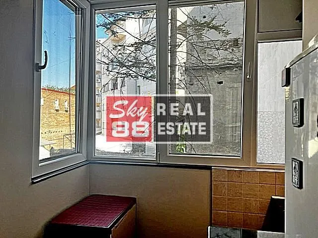 Enclosed balcony with a view of surrounding buildings.
