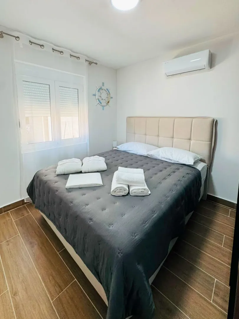 Bedroom with a double bed, air conditioning, and a window.