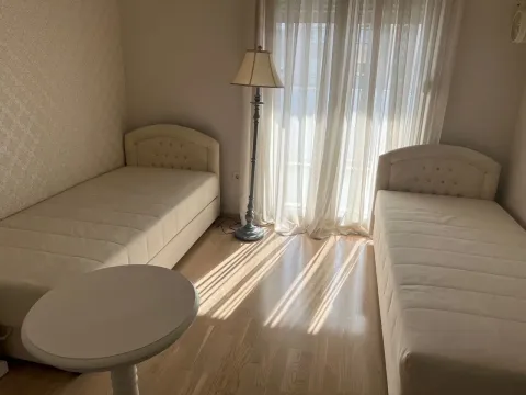 Svijetla spavaća soba sa dva kreveta za jednu osobu i podnom lampom. - image 7