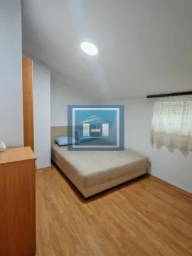 Small attic bedroom with a double bed and wooden flooring. - image 8