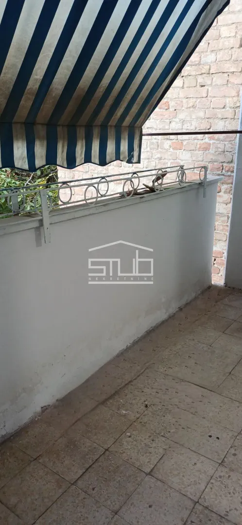 Smaller tiled balcony with railing and awning.