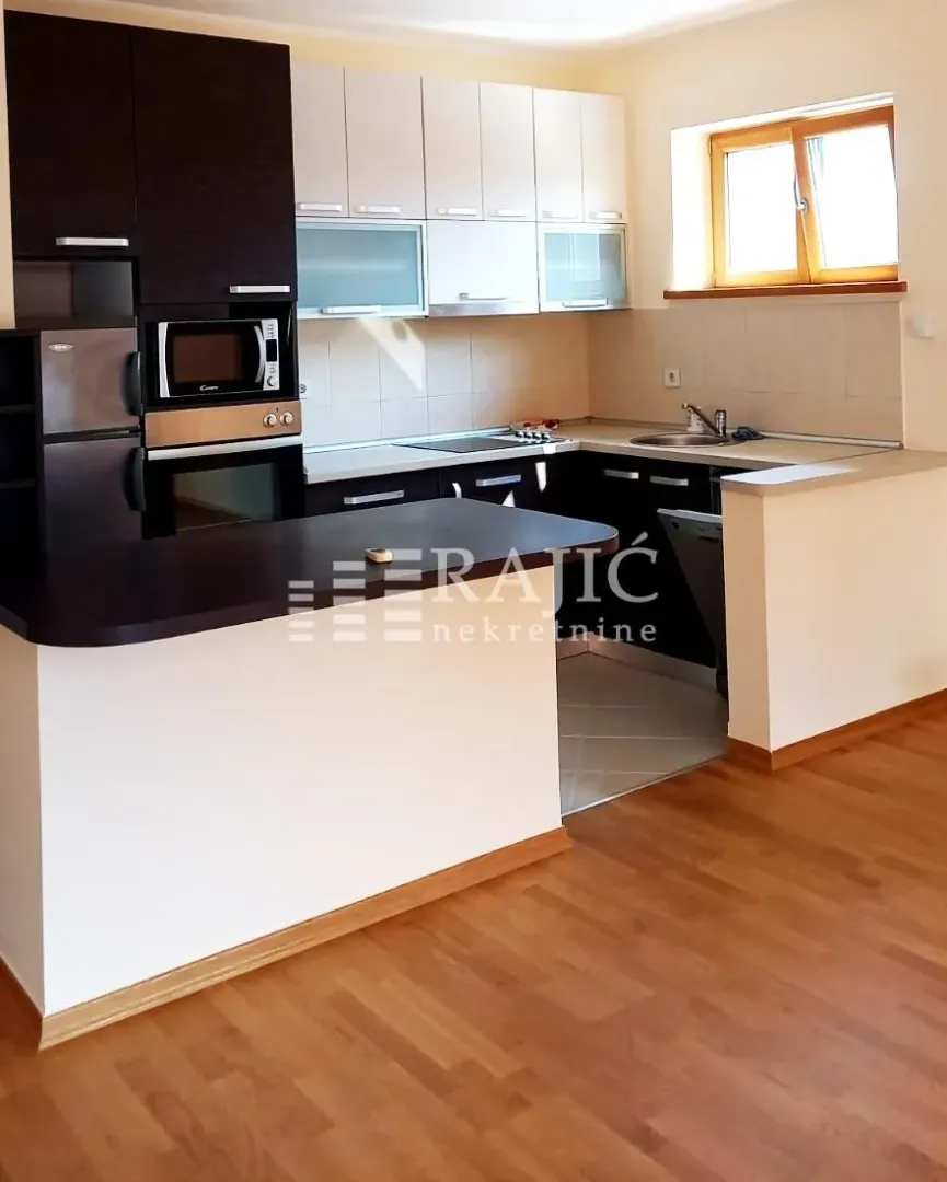 Modern kitchen with dark and white cabinets connected to the dining area.