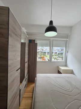 Namještena spavaća soba sa bračnim krevetom, velikim drvenim ormarom i prozorom. - image 4