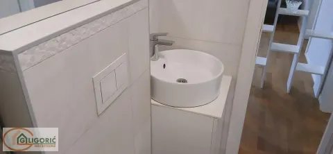 Pogled na umivaonik i deo kupatila sa pločicama. - image 11