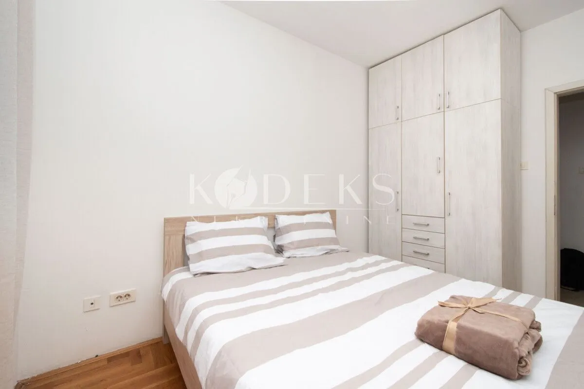 Bedroom with a double bed, white bedding, and a large wardrobe.