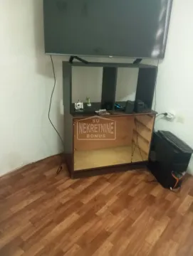 Dnevna soba sa televizorom postavljenom na komodu i laminatom na podu. - image 9