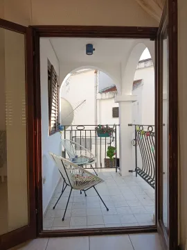 Covered terrace with seating furniture and a courtyard view. - image 11