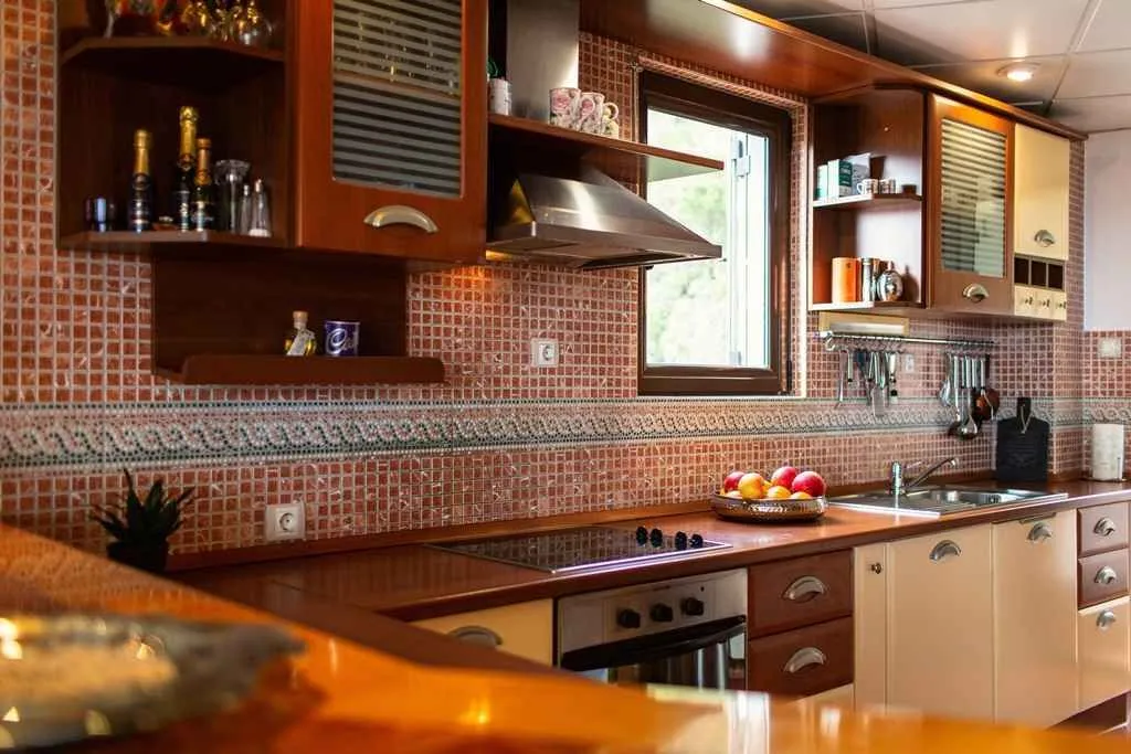 Equipped kitchen with wooden cabinets and mosaic tiles.