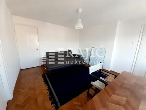 Living room with a sofa and parquet flooring. - image 3