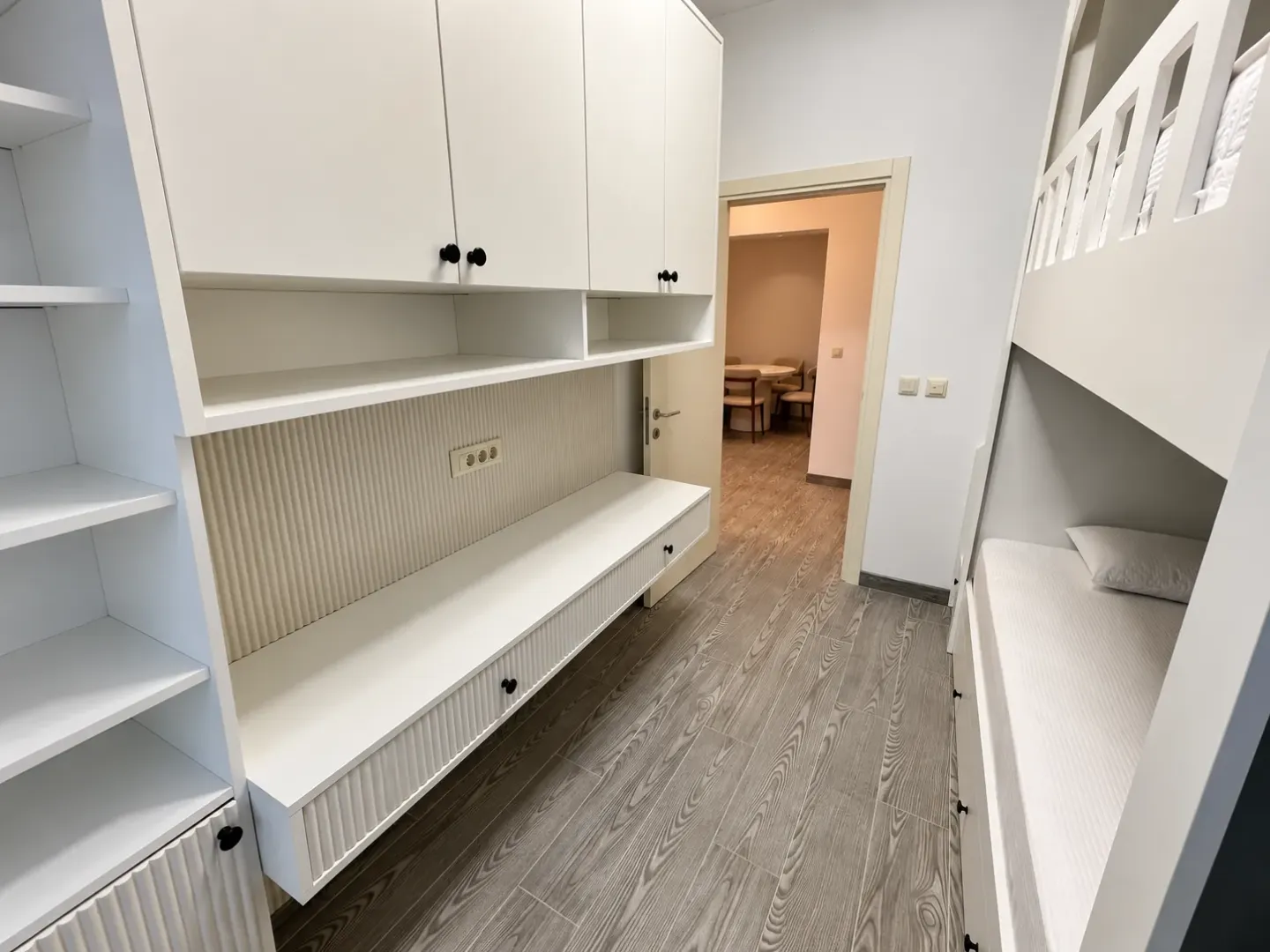 Children's bedroom with a bunk bed and built-in wardrobes.