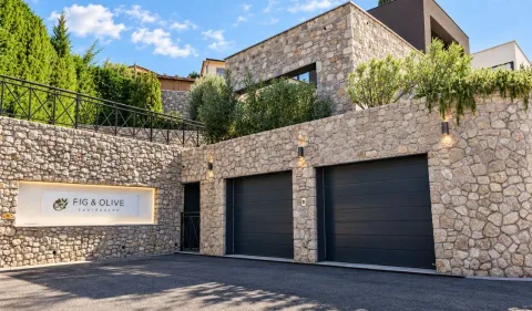 Building exterior with stone facade and garage doors. - image 23