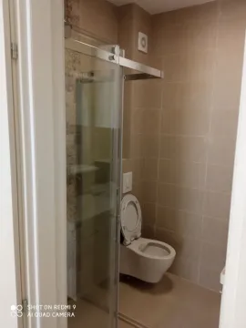 Manje kupatilo sa tuš kabinom i keramičkim pločicama u bež tonovima. - image 7