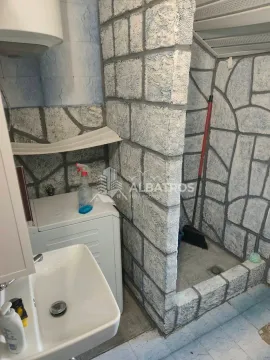 Kupatilo sa umivaonikom, veš mašinom i tuš kabinom obloženom kamenim pločicama. - image 5