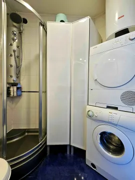Kupatilo sa tuš kabinom i mašinama za pranje i sušenje veša. - image 3