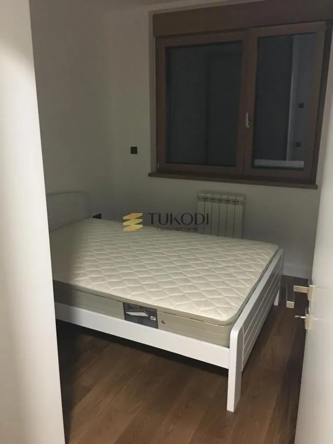 Manja spavaća soba sa krevetom i prozorom.