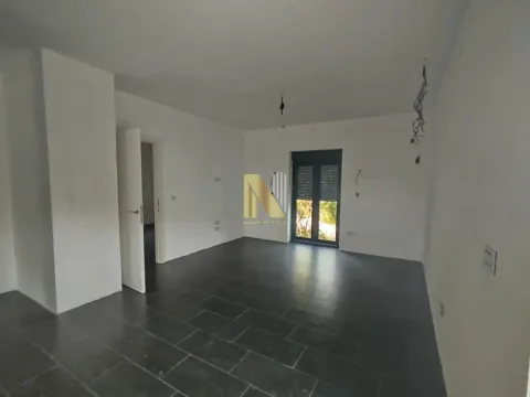 Prazna neopremljena prostorija sa tamnim podnim pločicama i belim zidovima. - image 23