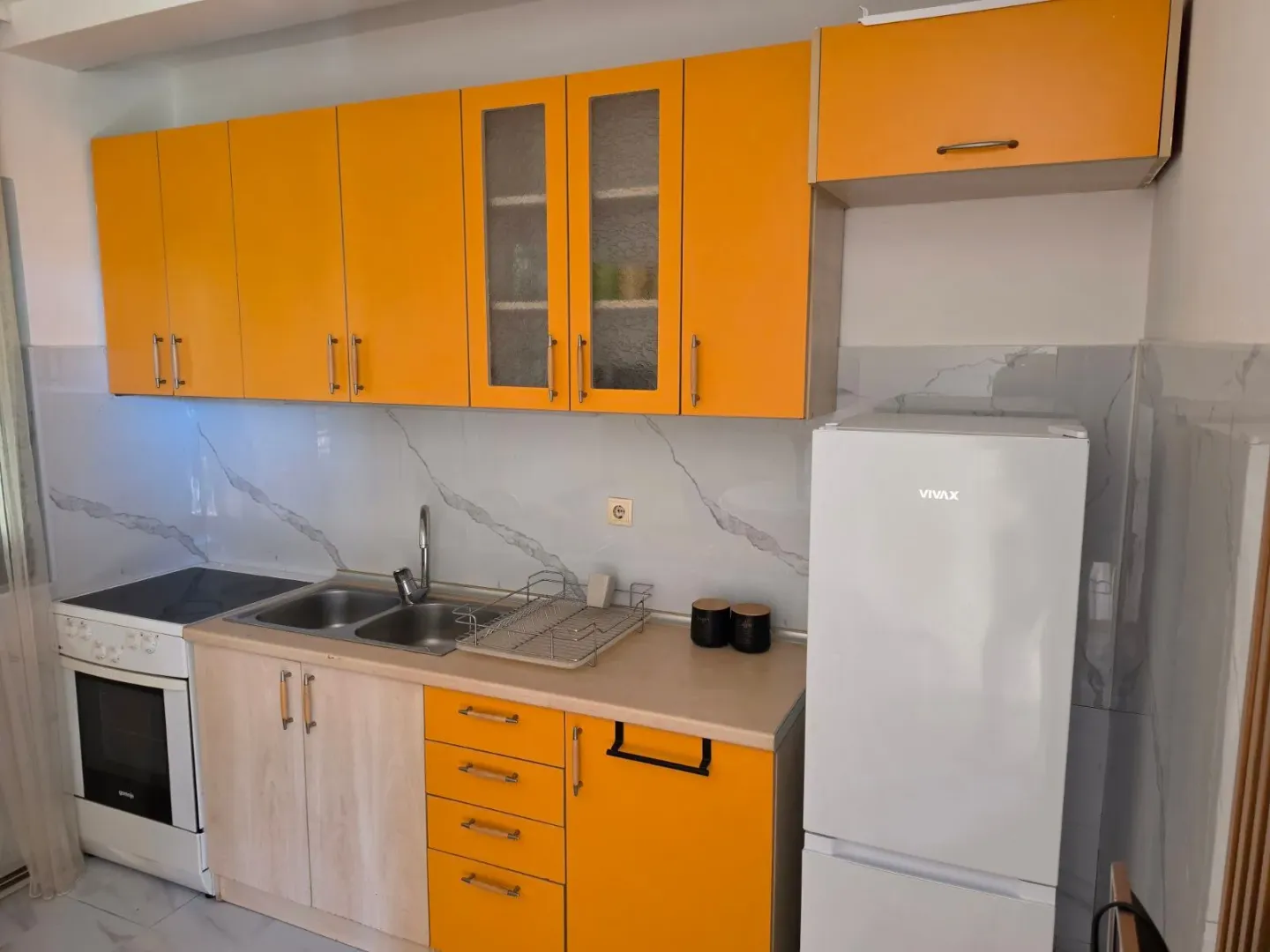 Small kitchen with yellow cabinets and a white refrigerator.