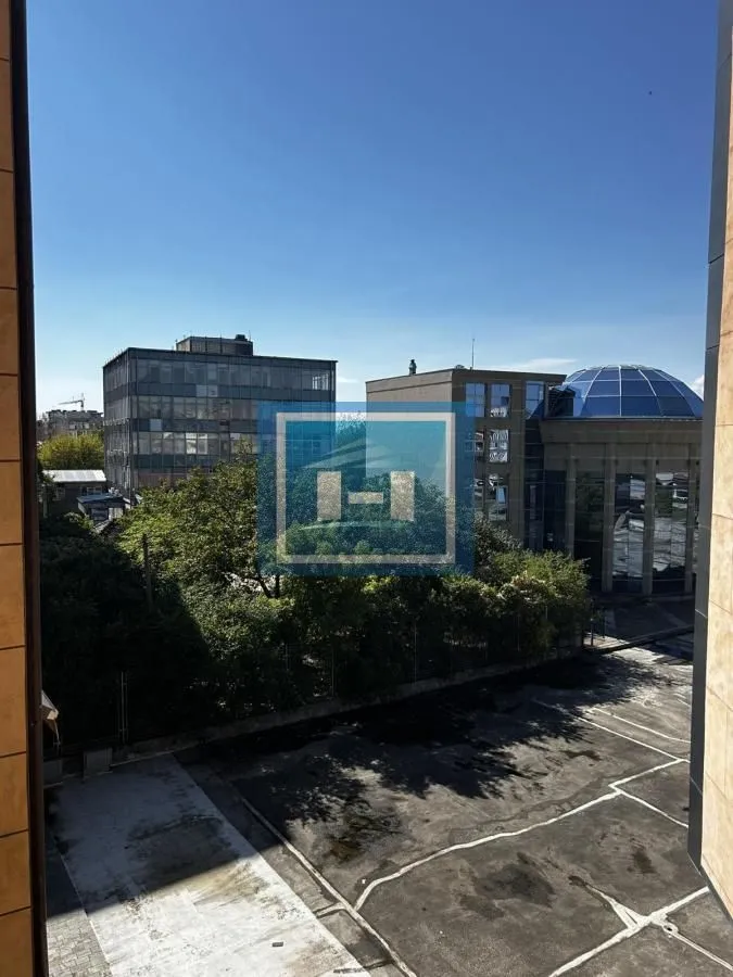 Pogled sa prozora na okolne zgrade i gradsko okruženje.