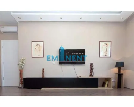 Living room with a TV, console unit, and decorative paintings on the wall. - image 3