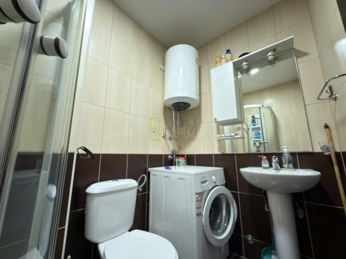 Manje kupatilo sa sanitarijama, tuš kabinom i veš mašinom.