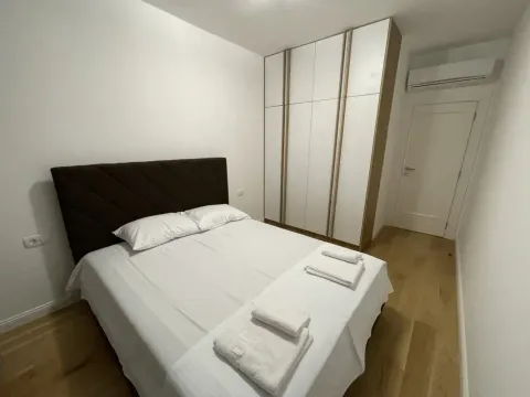 Tidy bedroom with a double bed, wardrobe, and air conditioning. - image 5