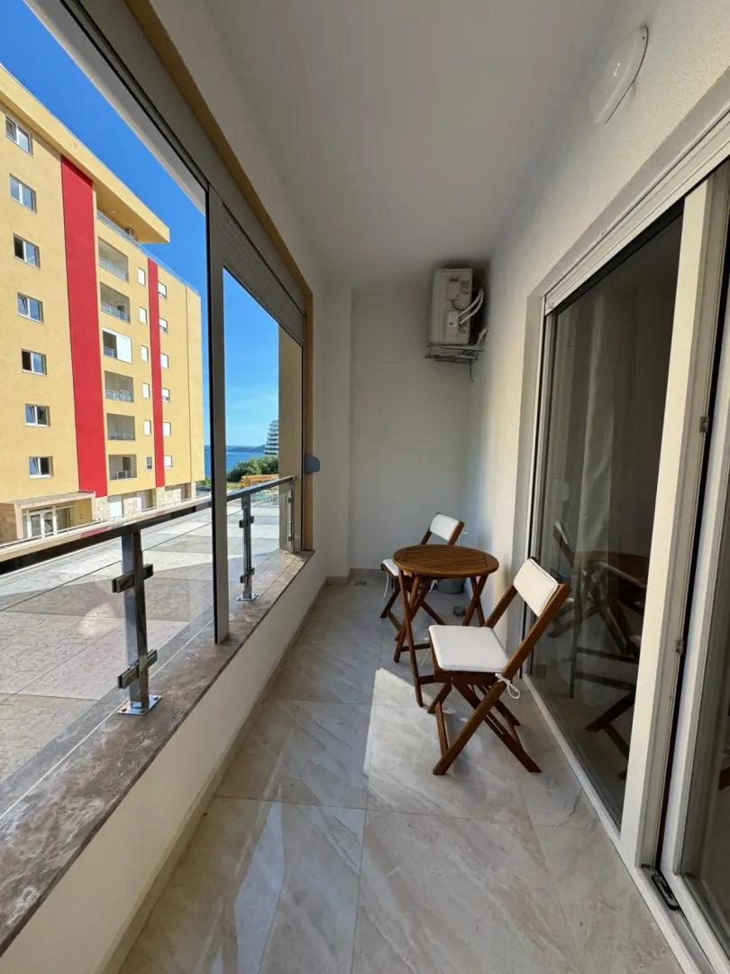 Manji namješteni balkon sa drvenim stolom i stolicama.