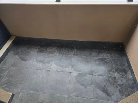 View of a small unfurnished balcony with dark ceramic tiles. - image 7