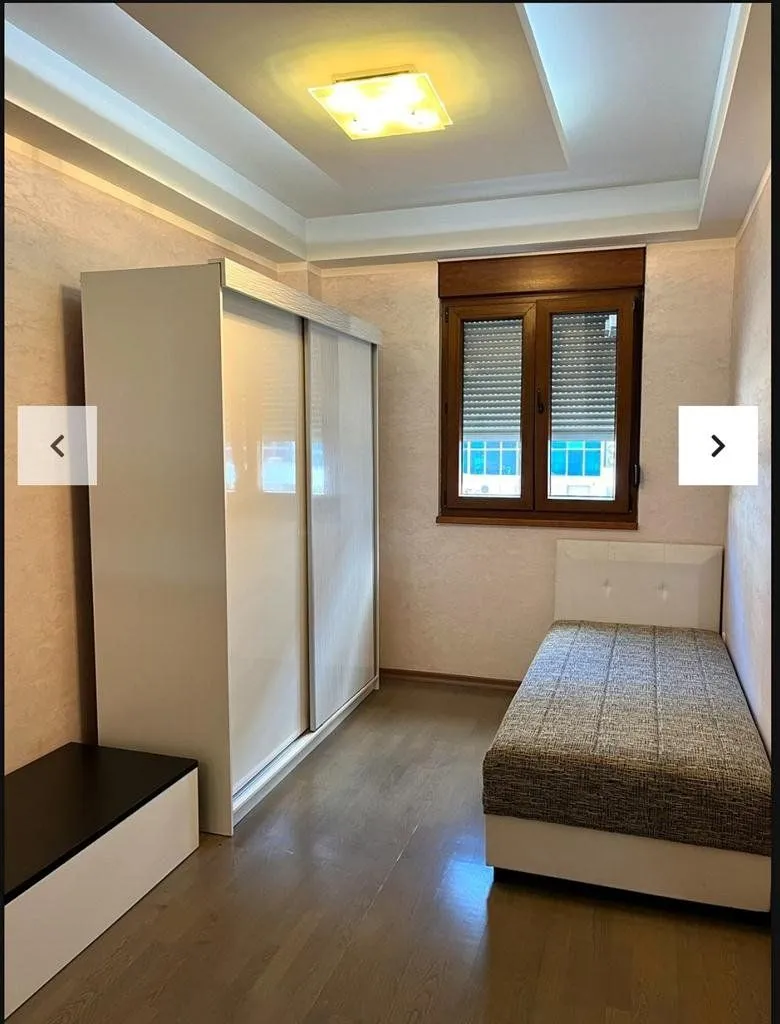Small bedroom with a bed, large wardrobe, and a window.