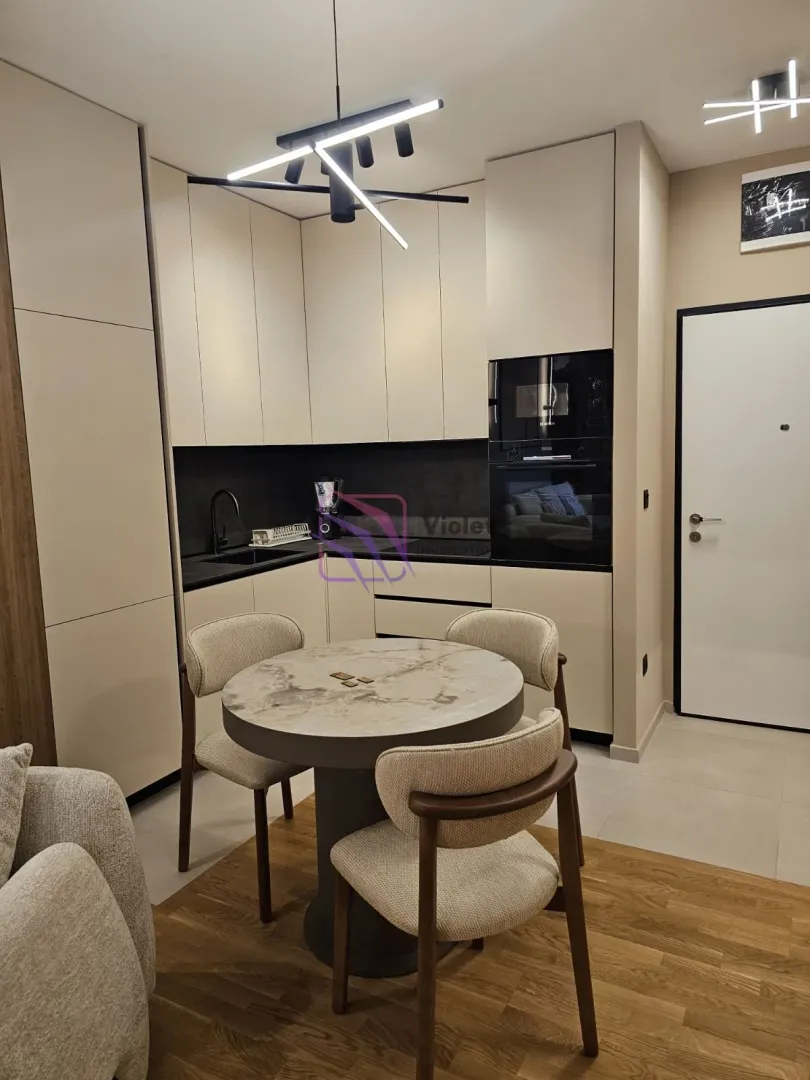 Modern kitchen with built-in appliances and a dining table with chairs.