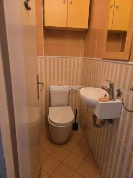 Manje kupatilo obloženo keramičkim pločicama sa toaletom, umivaonikom i zidnim ormarićem. - image 14