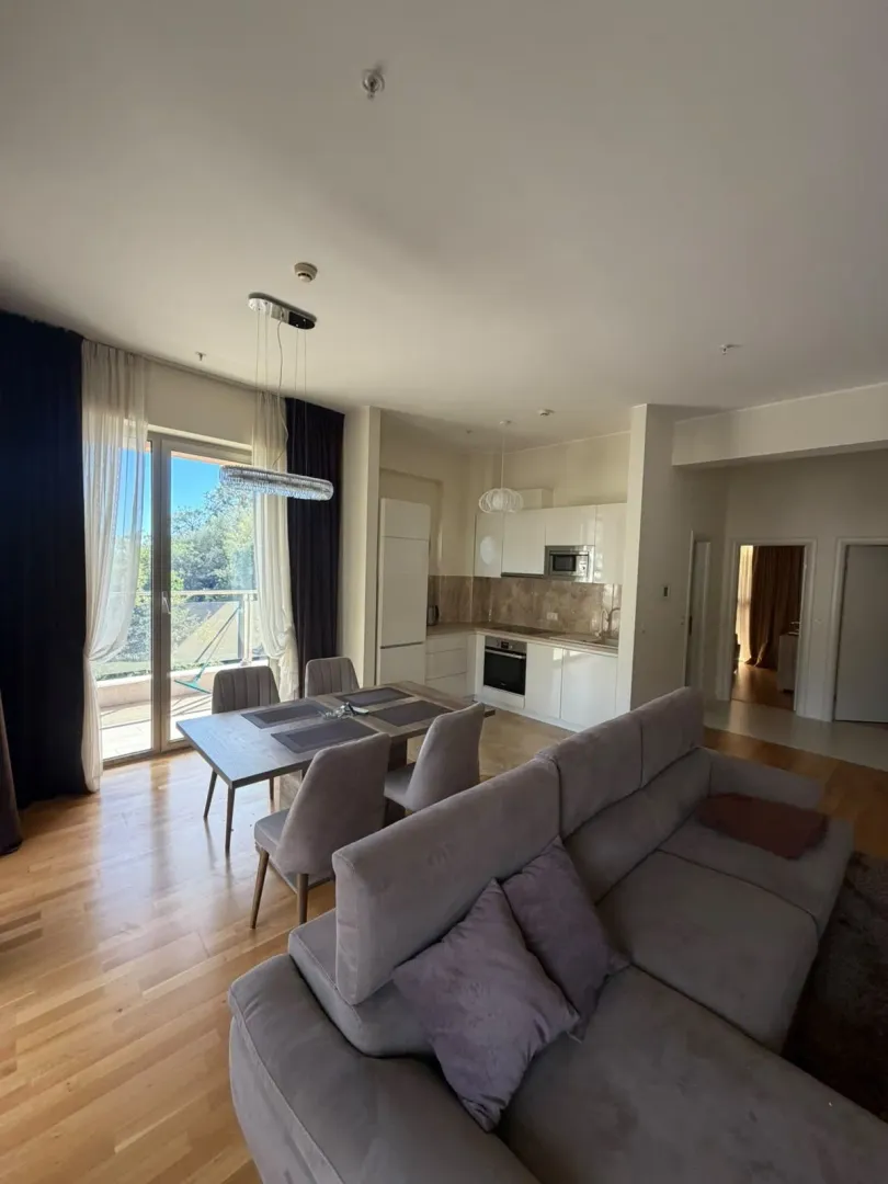 Spacious living room with a dining area and kitchen in the background.