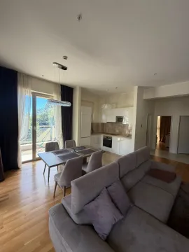 Spacious living room with a dining area and kitchen in the background. - image 7