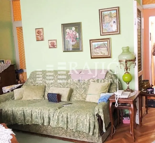 Living room with a sofa and paintings on the wall.