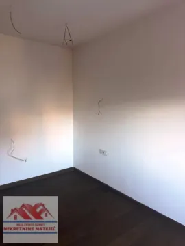 Prazna prostorija sa tamnim podom i zidovima okrečenim u belo. - image 12