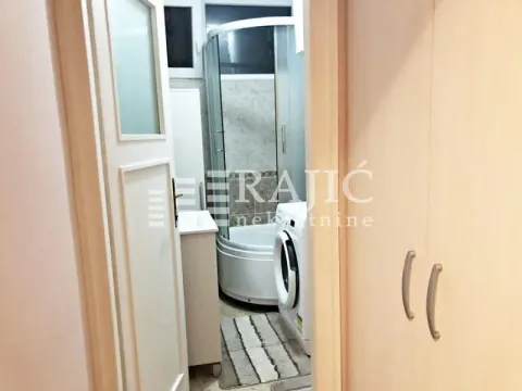 View of the bathroom with a shower cabin through the open door. - image 8