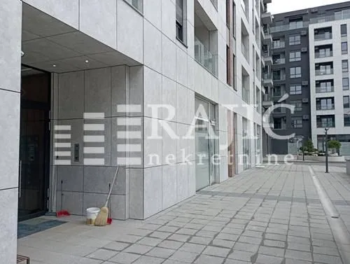 Exterior of a modern residential building with a paved plateau and entrance.