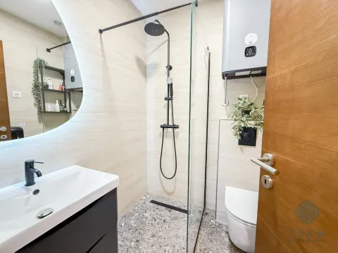 Modernly equipped bathroom with a shower cabin, washbasin, and toilet. - image 11