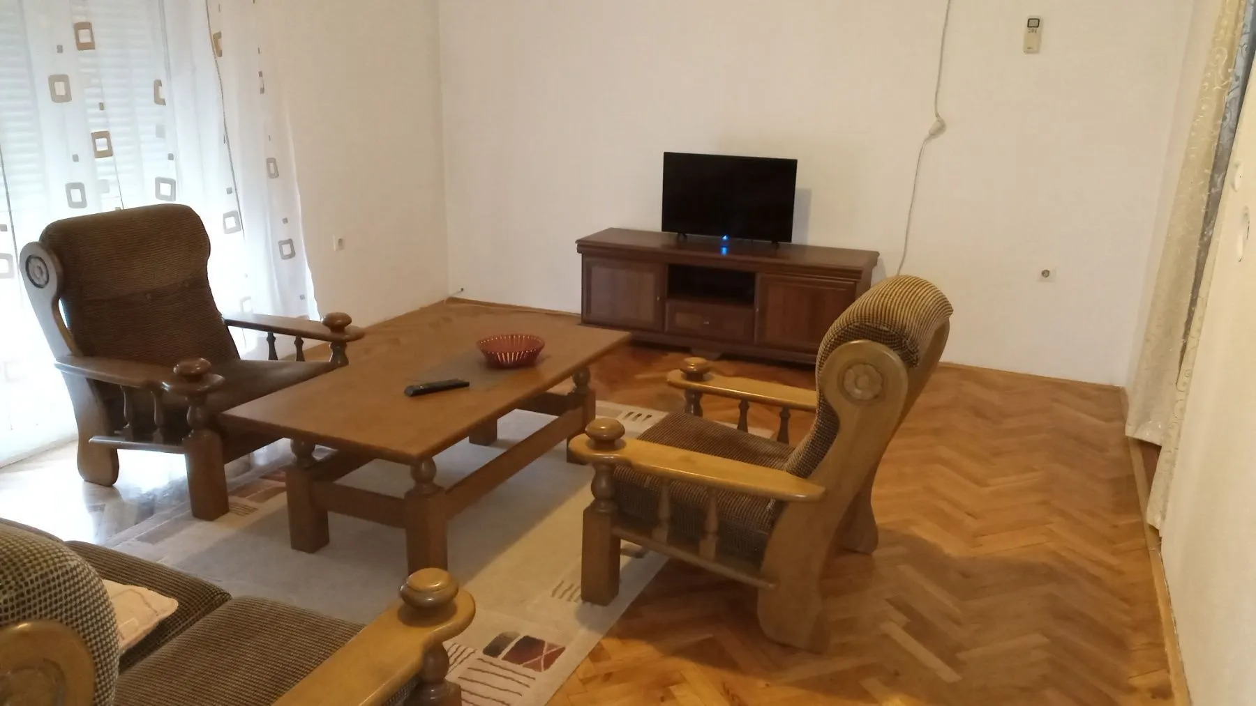 Living room with wooden furniture, a coffee table, and a TV.