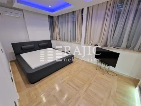 Furnished bedroom with a double bed and television. - image 6